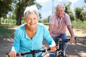 happy elderly couple riding bike