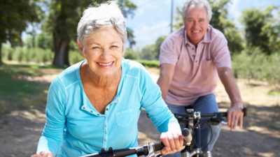happy elderly couple riding bike