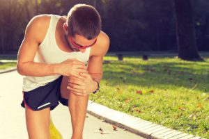 male athlete tending sore runner's knee