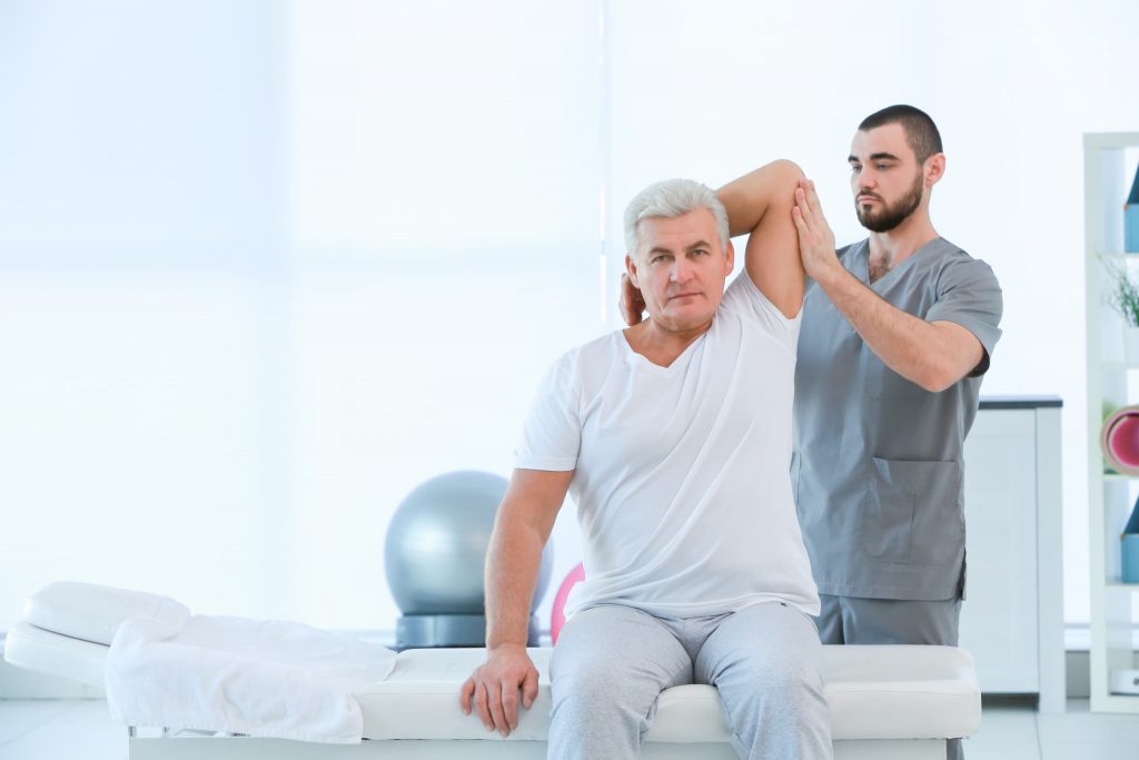 therapist treating a man with shoulder pain
