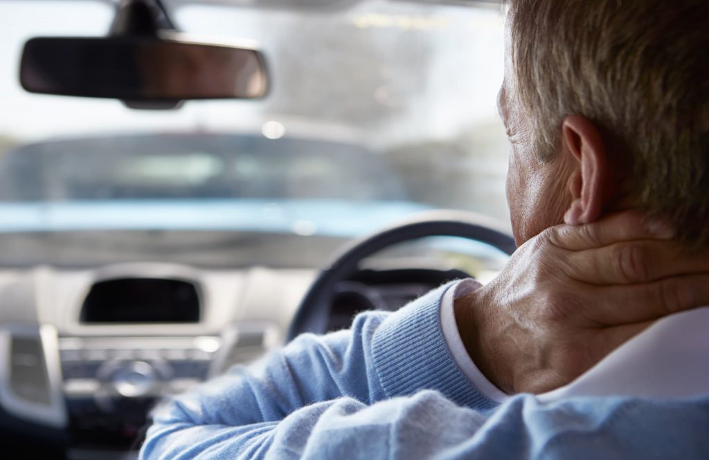 whiplash treatment | driver in car with whiplash