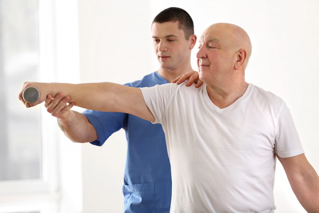 treating osteoporosis - physical therapist working with male patient