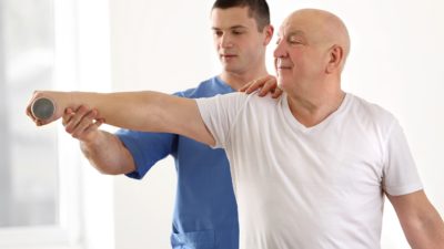 treating osteoporosis - physical therapist working with male patient