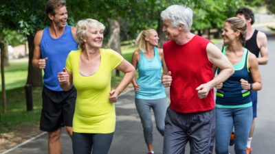senior couple jogging outside with children and partners
