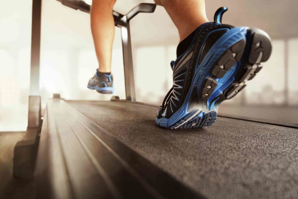 artistic shot of persons feet running on treadmill