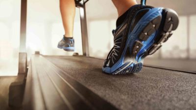 artistic shot of persons feet running on treadmill