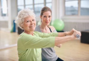 Exercise Therapy in Saskatoon - woman holding weights working with physiotherapist