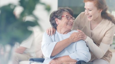 Happy patient is holding caregiver for a hand while spending time together