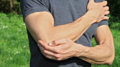 man holding sore elbow pain
