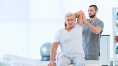 physical therapist and patient stretching