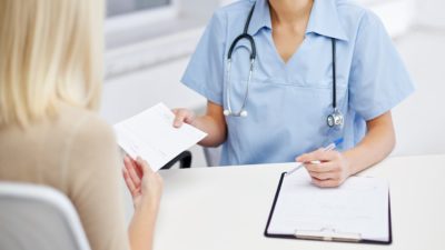 doctor handing paper to patient