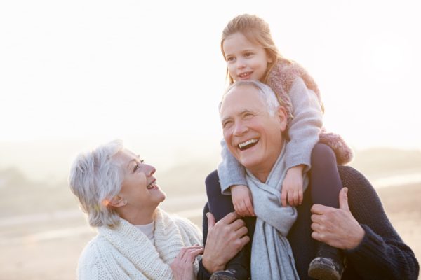 grandparents playing outdoors with grandchild