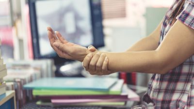 office worker holding sore forearm computer injury