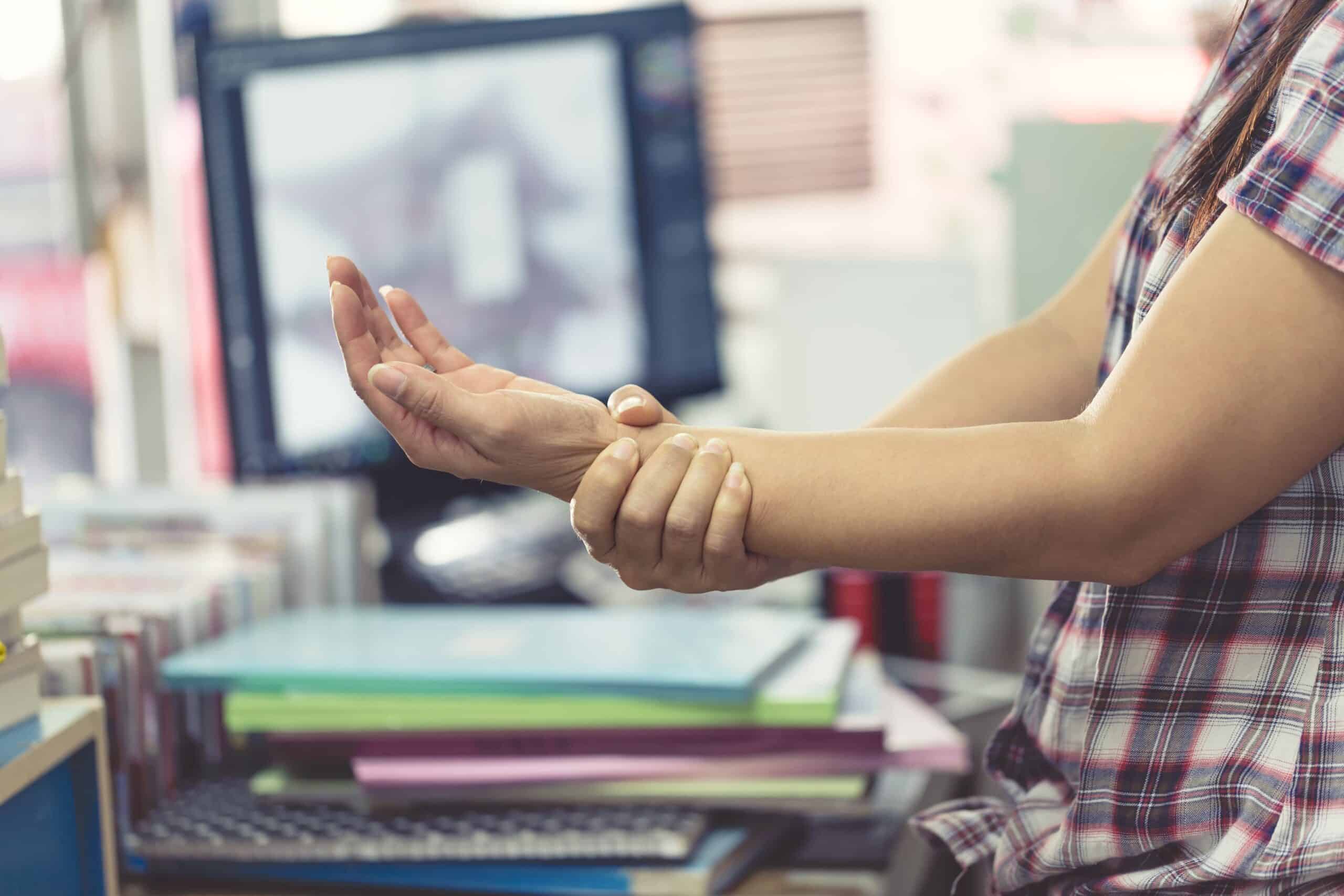 office worker holding sore forearm computer injury